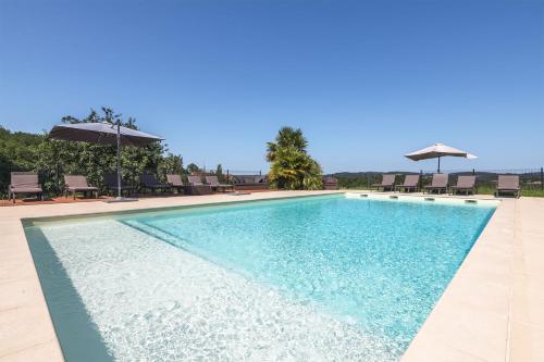une piscine avec chaises et parasols dans l'établissement Domaine des Grands Bois Privatisé, 9 chambres, 18 personnes, salle de jeux, piscine panoramique privée et chauffée, à Sergeac