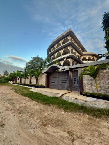 a building with two garage doors on a dirt road at Chukwani palace in Zanzibar City