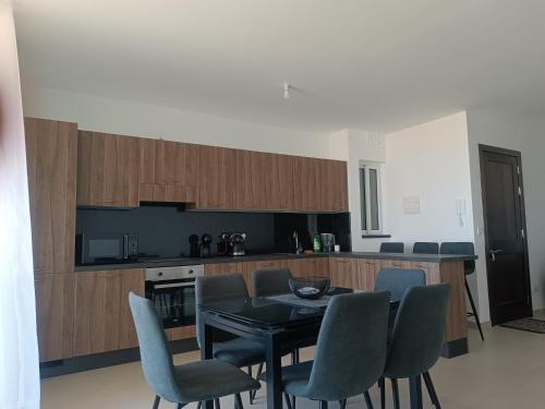 a kitchen with a table and chairs in a room at Boscolo Flats Nadur - Modern Rooms with private en-suite bathrooms in Nadur