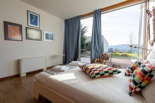 a bedroom with a bed with a large window at Casa da Corujeira - Montalegre in Montalegre