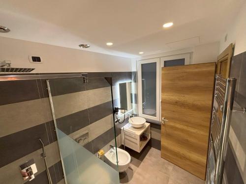 a bathroom with a toilet and a glass shower at Metropolitan in La Spezia