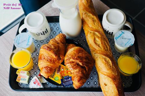 un plateau de nourriture avec des croissants et deux tasses de lait dans l'établissement NiD'Amour Gîte La Colombe, à Bézenac
