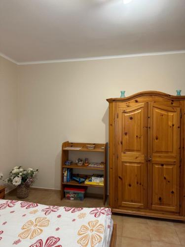 a bedroom with a wooden cabinet next to a bed at Kislőd Apartman in Kislőd