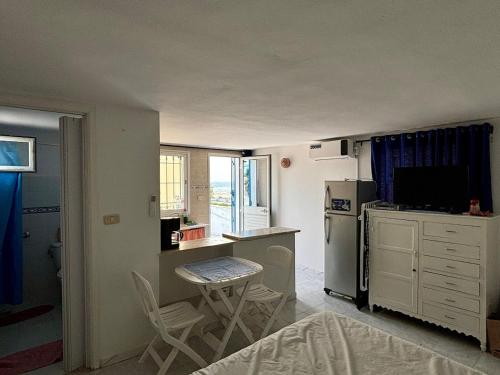 a small kitchen with a counter and a refrigerator at Charmant studio avec vue sur mer in Nabeul