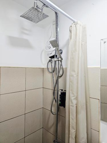 a shower in a bathroom with a shower curtain at Acellyne's Suites at Green 2 Residences with Netflix! in Dasmariñas