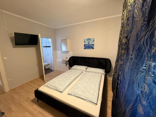 a small bedroom with a bed and a television at Rest Best L97 in Hamburg