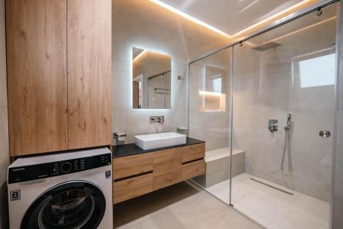 a washing machine in a bathroom with a shower at Skyline penthouse Sarande in Sarandë