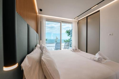a bedroom with a large bed with a large window at Skyline penthouse Sarande in Sarandë