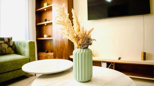 a green vase sitting on a table in a living room at Green Haven- Nature & Design - Riad Extension in Temara