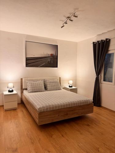 a bedroom with a bed and a painting on the wall at Kamilica Apartman in Krasici