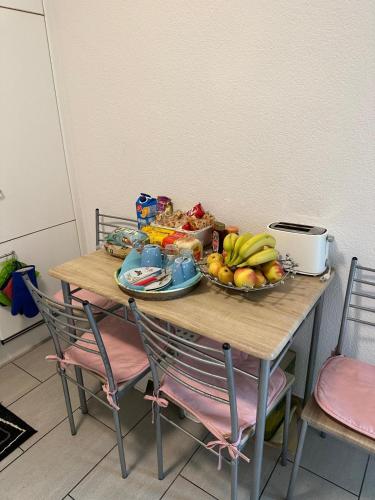 a wooden table with a bowl of fruit on it at Schönes Zimmer in der City Basel in Basel