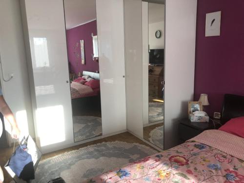 a bedroom with purple walls and a bed with a mirror at Schönes Zimmer in der City Basel in Basel