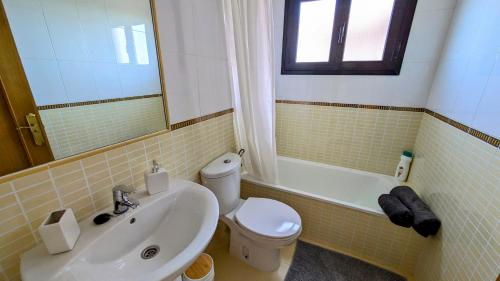 ein Badezimmer mit Waschbecken, Toilette und Spiegel in der Unterkunft Escapada Slow-Life Piscina, terrazas y olas cerca - Casa Pez in Majanicho
