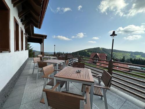 a row of tables and chairs on a balcony at Madarasi Gyopár Panzió in Izvoare