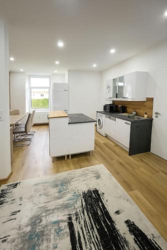 a large kitchen with white cabinets and a table at FELGRA Apartment #70 in Knittelfeld