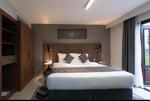 a bedroom with a large bed and a window at Marbella Resort in Sharjah