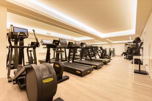 a gym with a row of treadmills and elliptical machines at Hotel Morfeo in Milan