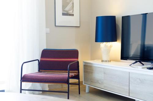 ein Wohnzimmer mit einem Sessel und einem Fernseher in der Unterkunft Casa Andreia in Olhão