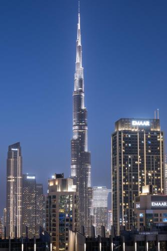 a view of the skyscrapers of a city at night at Burj khalifa and Canal views - Luxury Apartments for Rent in Dubai Business Bay in Dubai