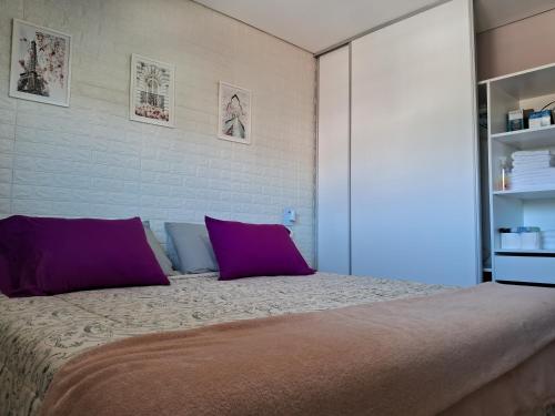 a bedroom with a large bed with purple pillows at Departamento Torre Murguía in San Salvador de Jujuy