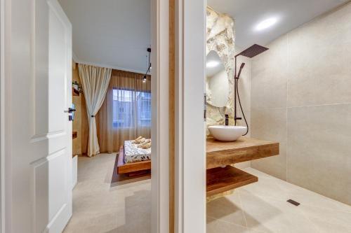 a bathroom with a sink and a mirror at Тематични апартаменти Дубай и Малдиви in Néa Péramos