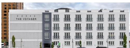 a rendering of a white building with a sign on it at The Voyager Inn in Anchorage