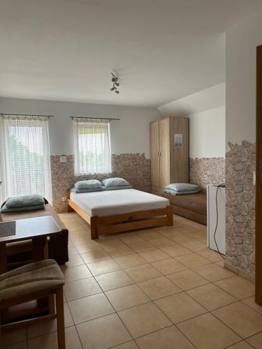 a bedroom with a bed and a table and a refrigerator at Pokoje gościnne Becia in Łeba