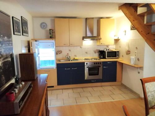 a small kitchen with blue cabinets and a microwave at Bayreuth Loft im Zentrum Altstadtflair mit Holz und Stil in Bayreuth