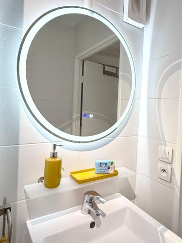 La salle de bains est pourvue d'un lavabo et d'un miroir rond. dans l'établissement Studio contemporain Blue lagoon 3 étoiles, à Hyères