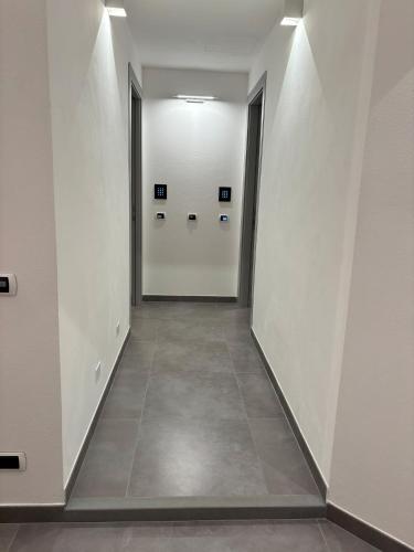 an empty hallway with white doors and a tile floor at Metropolitan in La Spezia
