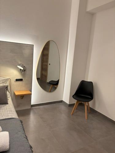 a bedroom with a black chair and a mirror at Metropolitan in La Spezia