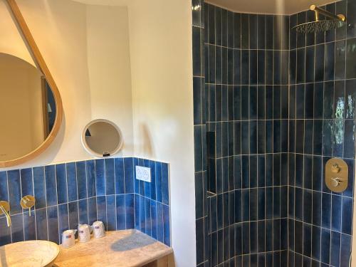 a bathroom with a blue tiled shower and a sink at Hotel Mas Des Barres in Saintes-Maries-de-la-Mer