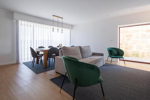 a living room with a couch and a table and chairs at Casa de Penedones - Ventos do Larouco in Penedones