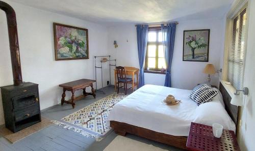 ein Schlafzimmer mit einem Bett und einem Herd in der Unterkunft Bulgarian country house near the sea in Banya