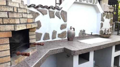 eine Steintheke vor einem gemauerten Kamin in der Unterkunft Bulgarian country house near the sea in Banya