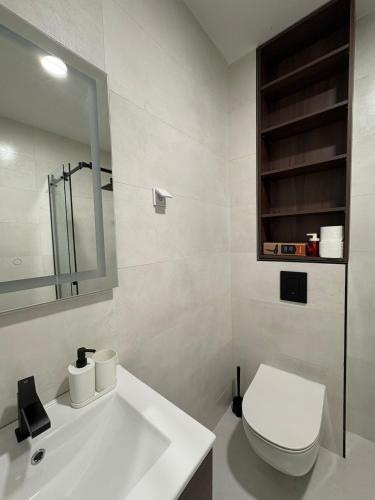 a white bathroom with a toilet and a sink at Luxury 2BR Sea View & Garage & Twin Towers Becici in Bečići