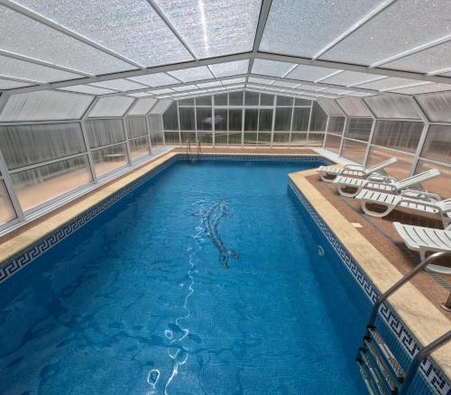 a large swimming pool with chairs in a building at Casa do Largo in Figueiró dos Vinhos