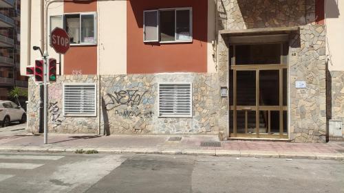 a stop sign in front of a building with graffiti at 41 Parallelo - Comfort rooms in Bari
