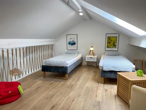 zwei Betten in einem Zimmer mit Holzboden in der Unterkunft Mado in Władysławowo