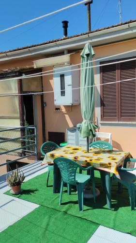 a patio with a table and an umbrella and chairs at Casa Graziella in Cecina