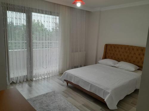 Un dormitorio con una cama y una ventana grande. en Doğan Suite, en Trabzon