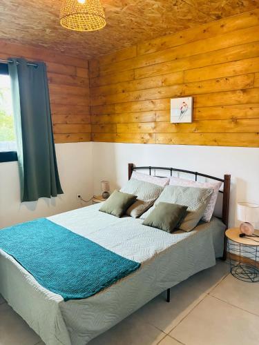 a bedroom with a bed with a wooden wall at Ti caz Désir in Le Tampon