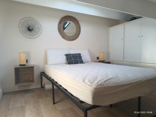 Appartement les flots bleues في فالراس بلاج: غرفة نوم مع سرير ومرآة على الحائط