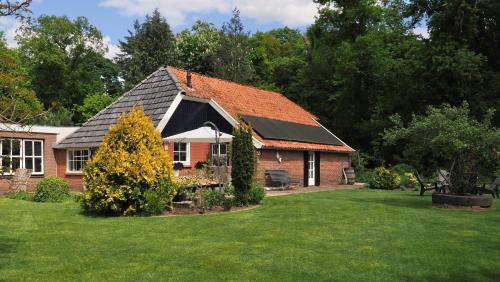 a red brick house with a green yard at De Wagenmaker in Markelo