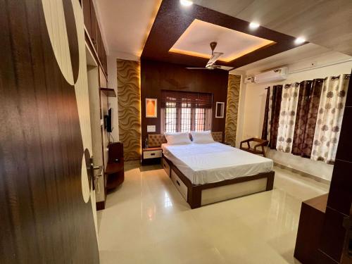 ein Schlafzimmer mit einem Bett und einem Fenster in der Unterkunft VSR Comforts Udupi in Udupi