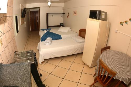 a small room with two beds and a refrigerator at Baleia Franca e Apart HS in Florianópolis