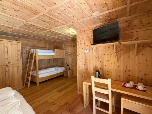 a cabin with a bed and a desk and a tv at Casa Bavo in Gerola Alta