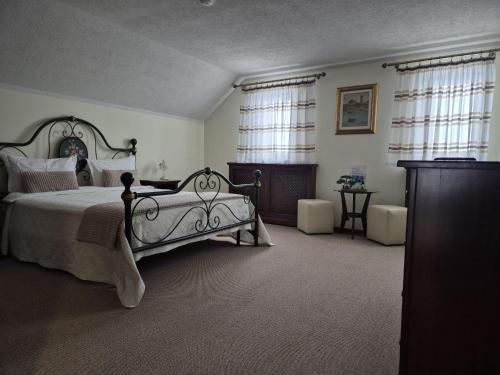 a large bedroom with a large bed and windows at Pensiunea Select in Curtea de Argeş