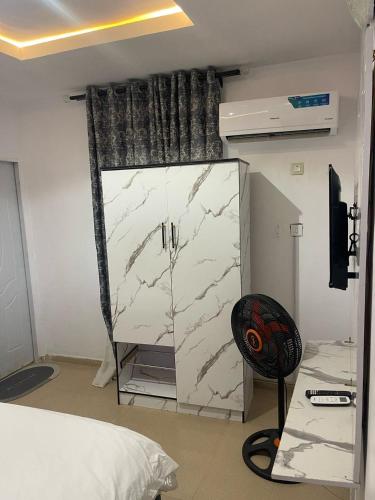 Un dormitorio con un armario de mármol blanco y una silla. en Gold House 40, en Ibadán