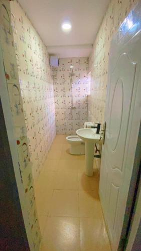un baño con inodoro y lavabo en Gold House 40, en Ibadán